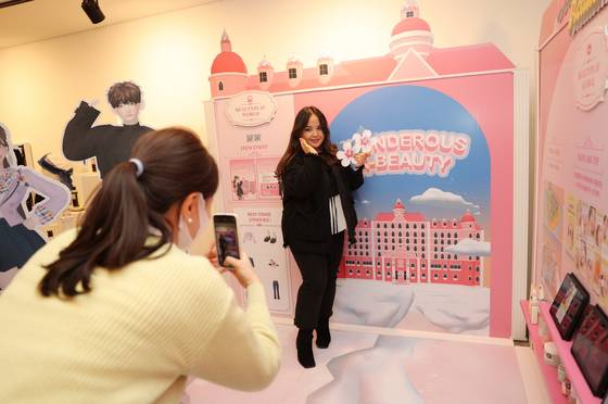 Visitors snap photos at photo op spots at the 2022 K-Beauty Brands Show at the Community House Masil in Myeong-dong, central Seoul, on Friday. [KOREA COSMETIC INDUSTRY INSTITUTE]