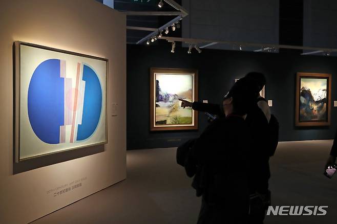 [홍콩=뉴시스] 박진희 기자 = 29일 크리스티 홍콩 프리뷰 전시장인 홍콩 컨벤션 센터(HKCEC)를 찾은 관람객이 이성자 작가의 Cite Janvier73' 작품을 살펴보고 있다. 크리스티 홍콩은 올해 마지막 경매로 추정가 총 12억~17억 홍콩 달러(한화 약 2040억) 규모의 총 5개 경매를 펼친다. 2022.11.29. pak7130@newsis.com