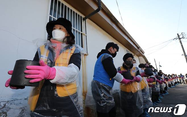 30일 오후 서울 노원구 상계동 일대에서 고려아연 임직원들과 적십자 봉사원들이 취약계층에게 전달할 연탄을 나르고 있다. 2022.11.30/뉴스1 ⓒ News1 송원영 기자