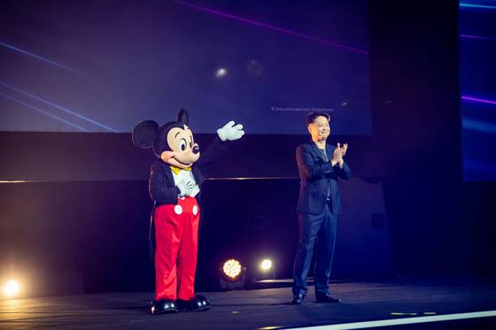 Luke Kang, president of The Walt Disney Company Asia Pacific, with Mickey Mouse at the opening ceremony of the Disney Content Showcase in Singapore. [THE WALT DISNEY COMPANY]