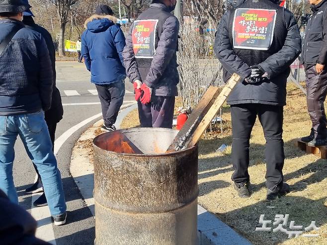 한파가 찾아온 30일 화물연대 조합원들이 몸을 녹이기 위해 불을 때고 있다. 정성욱 기자