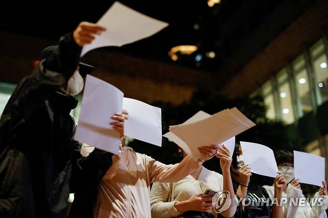 '제로 코로나' 반대시위 현장서 백지 나눠주는 홍콩 여성들 (홍콩 로이터=연합뉴스) 29일(현지시간) 중국 홍콩 홍콩대에서 열린 우루무치 화재사건 피해자 추도식에서 여성들이 중국 정부의 코로나19 규제에 반대하는 시위를 벌일려고 백지를 나눠주고 있다. 2022.11.30 ddy04002@yna.co.kr