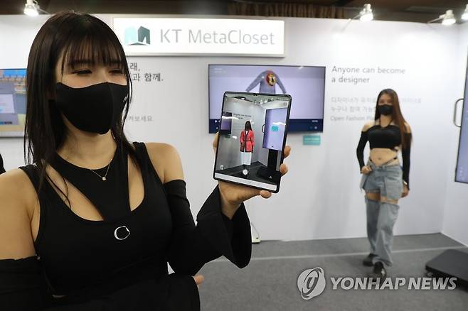 메타패션 착장은 이렇게 (서울=연합뉴스) 류효림 기자 = 30일 서울 강남구 삼성동 섬유센터에서 열린 메타패션 쇼케이스에서 모델들이 메타패션 플랫폼 메타클로셋(Meta Closet) 앱을 소개하고 있다. 2022.11.30 ryousanta@yna.co.kr