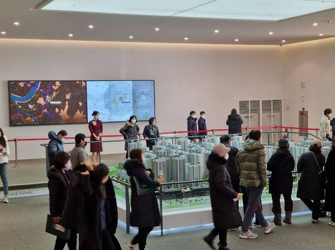 서울 강동구 둔촌동 '둔촌주공 아파트(올림픽파크 포레온)' 견본주택 1층. 방문객들이 단지 전경 모형을 구경 중이다/사진=황서율 기자chestnut@