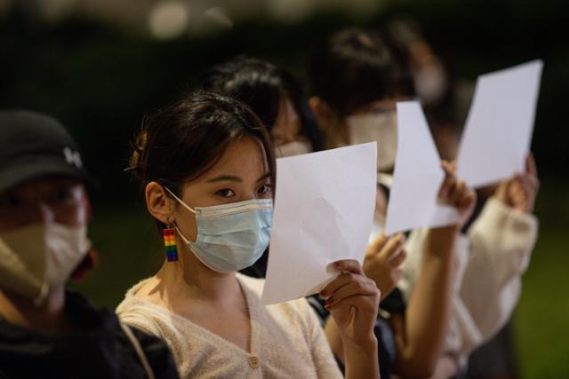 중국 유학생들이 지난달 29일 홍콩 홍콩대에서 열린 중국 우루무치 화재 희생자 추모 집회에서 중국 정부의 '제로 코로나' 정책에 반대하는 의미로 백지를 들고 시위하고 있다. 홍콩=EPA 연합뉴스