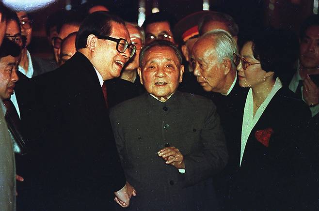 중국 시장경제발전을 이끈 장쩌민 전 국가주석이 30일 백혈병 등 지병으로 상하이에서 치료를 받다 사망했다. 사진은 1992년 10월 19일 베이징 인민대회당에서 완리 전 중국 전국인민대표대회 상무위원장, 덩샤오핑의 딸 덩 룽(맨 오른쪽)이 지켜보는 가운데 88세였던 덩샤오핑(가운데)이 장쩌민 전 총서기(왼쪽)와 대화하고 있는 모습이다. 1989년 유혈 진압으로 막을 내린 톈안먼 사태 이후 덩샤오핑은 장 전 주석에게 총서기와 군사위원회 주석직을 맡겼다. AP연합뉴스