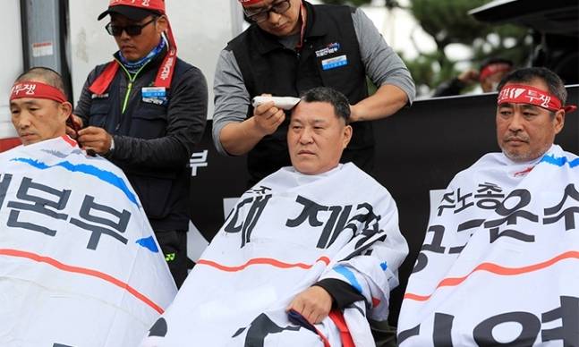 민주노총 공공운수노조 화물연대본부 총파업 엿새째인&nbsp;29일 정부가 사상 첫 업무개시명령을 발동하자 이날 제주시 제주항 6부두 앞 도로에서 화물연대 제주지부 관계자들이 업무개시명령을 규탄하며 삭발식을 하고 있다.&nbsp; &nbsp;연합뉴스