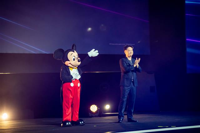 디즈니의 마스코트인 미키 마우스가 30일 싱가포르에서 열린 ‘디즈니 쇼케이스 2022’에서 루크 강 월트디즈니 컴퍼니 아태지역 총괄 사장의 소개로 등장해 관객들에게 인사하고 있다.월트디즈니 제공