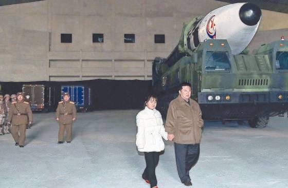 북한 김정은 국무위원장이 지난달 18일 딸의 손을 잡고 신형대륙간탄도미사일 '화성-17형' 앞을 걷고 있다. 국정원은 북한 관영매체를 통해 소개된 김정은의 딸에 대해 '9세 김주애'라고 추정했다. [뉴스1]