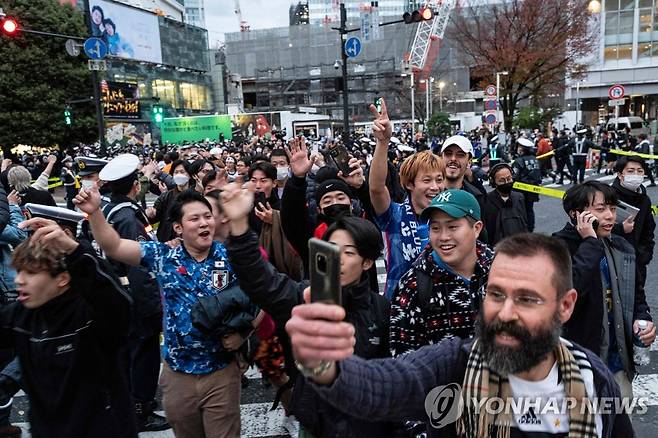 일본 축구팬들, 자국팀 스페인 상대 역전승으로 '2연속 16강'에 환호 (도쿄 AFP=연합뉴스) 일본 축구 국가대표팀이 2022 카타르 월드컵 조별리그 E조 스페인과의 경기에서 승리한 2일, 도쿄에서 일본 축구를 응원하는 팬들이 기뻐하고 있다. 이날 스페인에 2-1 역전승을 거둔 일본은 E조 1위로 조별리그를 마감, 2018 러시아 월드컵에 이어 두 대회 연속 16강 진출에 성공했다. 2022.12.02 alo95@yna.co.kr