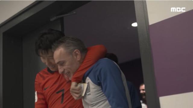 손흥민이 파울루 벤투 국가대표팀 감독의 목을 감싸며 라커룸으로 들어오고 있다. 한국 대표팀은 3일 2022 카타르 월드컵 조별리그 최종전 포르투갈과 경기에서 2-1로 승리해 16강 진출을 확정했다. MBC 유튜브 채널 캡처