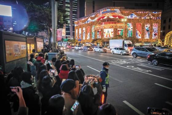 지난해 11월 서울 신세계 명동 본점 외관에 설치 돼 있는 미디어 파사트를 보기위해 모인 시민들로 인도가 북적이고 있다. 전민규 기자