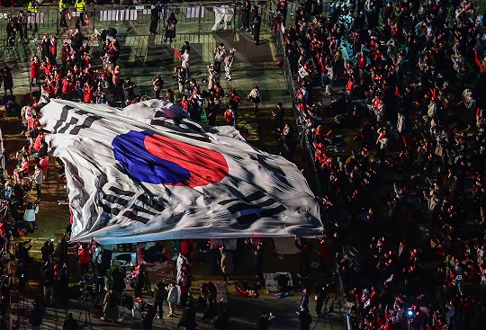 2022 카타르 월드컵 대한민국과 우루과이의 조별 예선 첫 경기가 열린 24일 오후 서울 종로구 광화문 광장에서 붉은 악마 응원단과 시민들이 태극기를 옮기며 거리 응원을 하고 있다. 사진=뉴시스