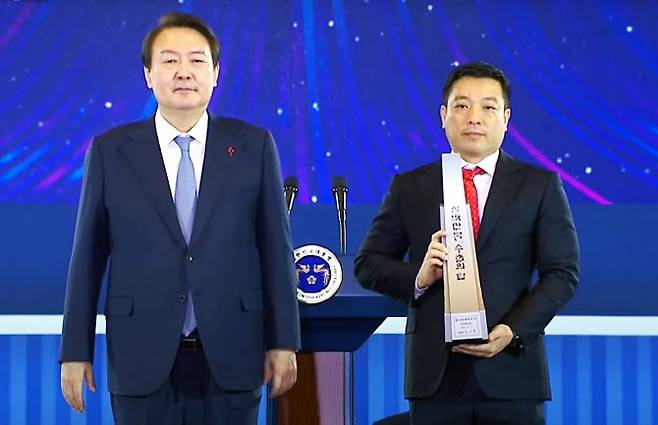 플리토가 5일  서울 코엑스에서 열린 한국 제59회 무역의 날 기념식에서 ‘300만불 수출의탑’과 ‘서비스탑’을 동시 수상했다. 사진은 윤석열 대통령과 이정수 플리토 대표.(사진=플리토 제공)