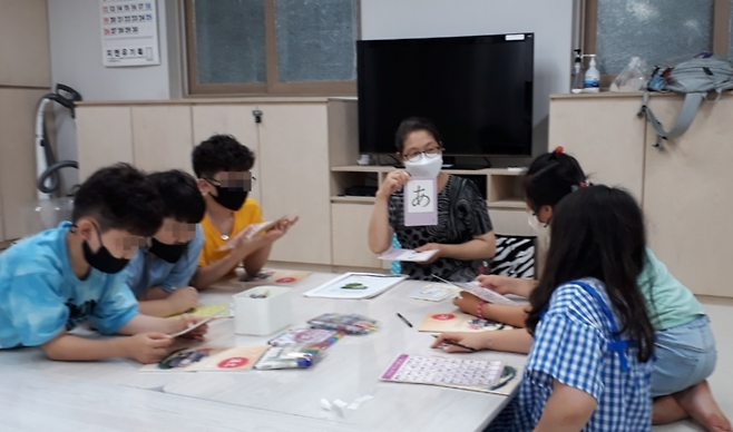 어르신들이 집으로 돌아간 오후 시간대 돌봄 교실로 운영됐던 서울 마포구 공덕동 아현1동경로당에서 아이들이 일본에서 귀화한 주민자치위원과 함께 일본어 공부를 하고 있다. 마포구 제공