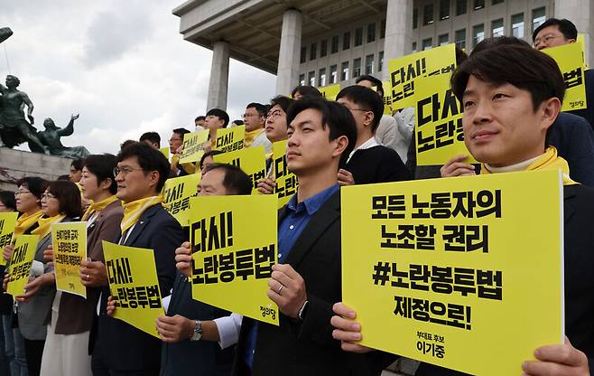 정의당 이은주 비상대책위원장과 당직선거 출마자들이 지난 10월6일 국회 본관 앞 계단에서 열린 노란봉투법 연내 입법을 촉구하는 결의대회에서 손팻말을 들어 보이고 있다. 연합뉴스