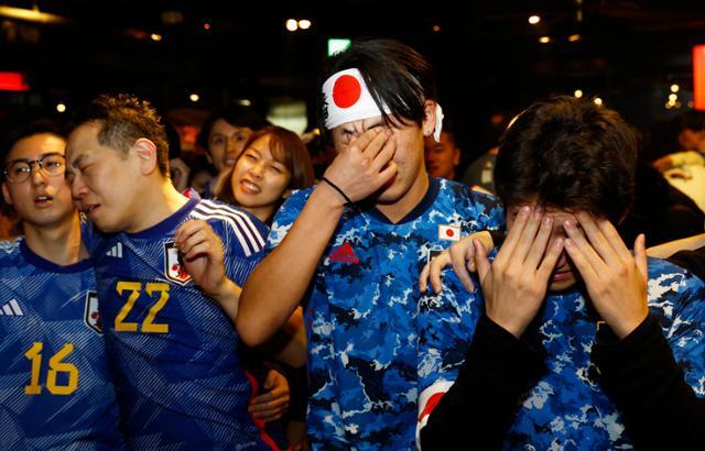 6일(한국시간) 새벽 2022 카타르 월드컵 16강전에서 일본 대표팀이 승부차기 끝에 크로아티아에 패해 8강 진출이 또다시 좌절되자 도쿄의 한 주점에서 TV를 보며 단체 응원을 하던 서포터들이 탄식하고 있다. 도쿄=로이터 연합뉴스