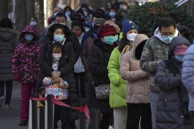 지난 4일(현지시간) 중국 베이징의 한 선별진료소에 시민들이 코로나19 검사를 받기 위해 줄서있다. 당국은 주요 도시에서 고강도 ‘제로 코로나’ 정책에 반대하는 시위가 발생한 후 방역 정책을 빠르게 완화하고 있다. AP연합뉴스