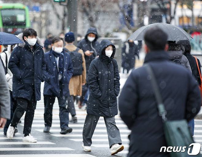 서울 시내 한 거리에서 시민들이 눈을 맞으며 거리를 지나고 있다./뉴스1 ⓒ News1 김도우 기자