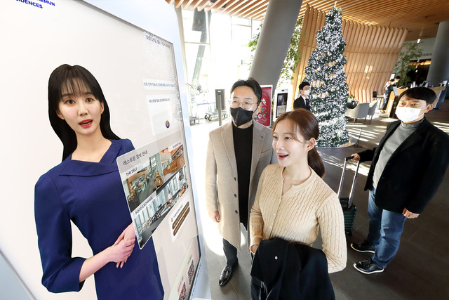 KT 모델이 노보텔 앰배서더 서울 동대문 호텔＆레지던스 1층 로비에 설치된 'AI 컨시어지' 앞에서 호텔 서비스 안내를 받고 있다. /KT제공
