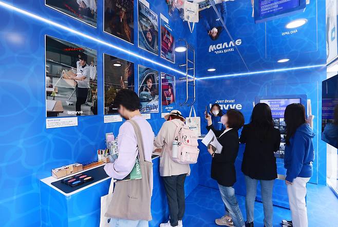 지난 10월 부산 해운대구 영화의 전당에 마련된 웨이브 홍보 부스에서 다양한 체험을 하는 방문객들 모습. /연합뉴스