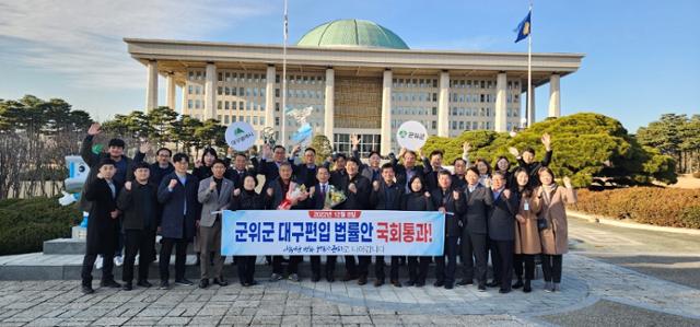 경북 군위군 관계자들이 8일 오후 서울 영등포구 여의도동 국회 앞에서 군위군의 대구 편입 법안 통과를 자축하고 있다. 군위군 제공