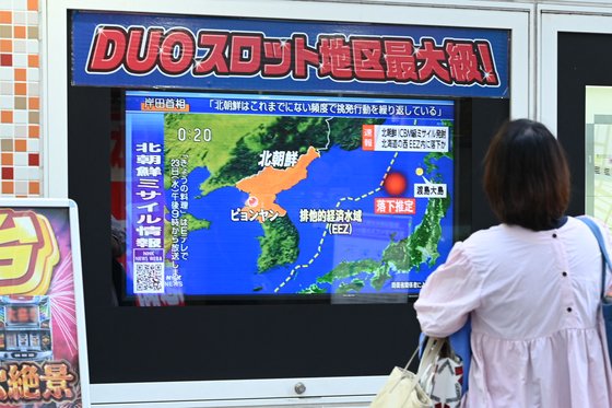 지난달 18일 일본 도쿄에서 한 시민이 북한의 미사일 발사 소식이 나오는 전광판을 보고 있다. AFP=연합뉴스