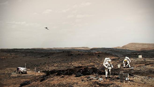 미래 화성 탐사 상상도. 화성 표면을 조사 중인 우주비행사의 뒤편에서 무인기가 비행을 하고 있다. 미국 항공우주국(NASA) 제공