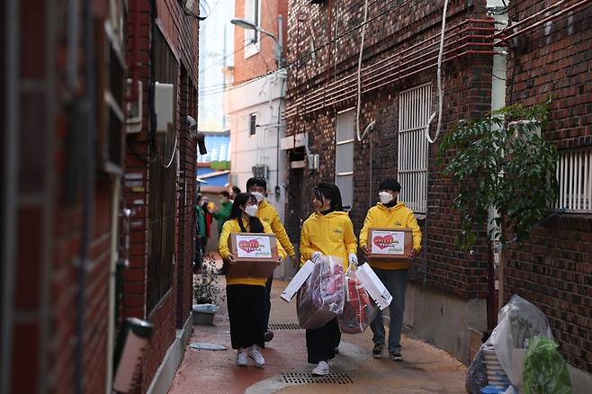 [서울=뉴시스] 윤석열 대통령 부인 김건희 여사가 8일 부산 부전동 부산진구새마을지회에서 생필품 포장을 마친 후 대학생 봉사자들과 함께 어르신들에게 생필품을 직접 전달하고 있다. (사진=대통령실 제공) 2022.12.08. photo@newsis.com *재판매 및 DB 금지