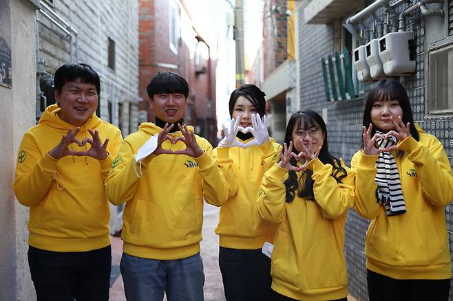 [서울=뉴시스] 윤석열 대통령 부인 김건희 여사가 8일 부산 부전동 부산진구새마을지회에서 직접 포장한 생필품을 어르신들에게 전달한 뒤 대학생 봉사자들과 기념촬영하고 있다. (사진=대통령실 제공) 2022.12.08. photo@newsis.com *재판매 및 DB 금지