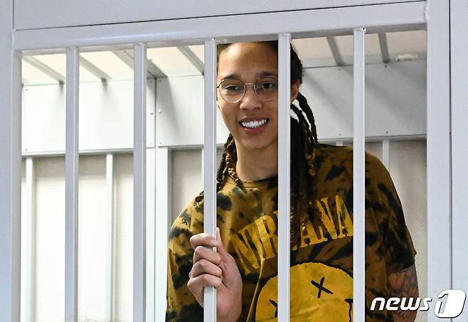 미국 WNBA 농구 슈퍼스타 브리트니 그라이너가 2022년 7월 15일 모스크바 외곽의 킴키 법원에서 열리는 공판을 기다리며 피고인 케이지에서 웃고 있는 모습. 조 바이든 미 대통령에 따르면 그라이너는 8일 미국에 수감중인 악명 높은 무기 밀매업자와 맞교환되어 석방되었다. ⓒ AFP=뉴스1 ⓒ News1 권영미 기자