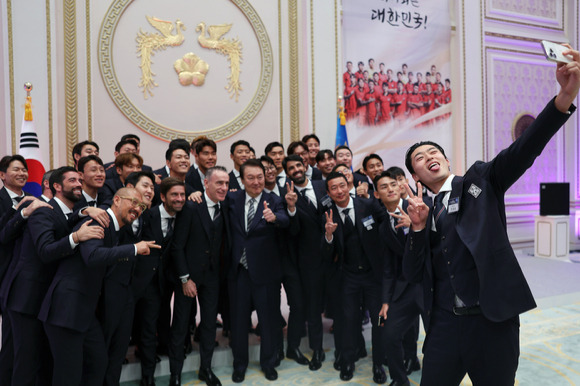 윤석열 대통령이 8일 청와대 영빈관에서 열린 카타르 월드컵 축구 국가대표팀 환영 만찬에서 파울로 벤투 감독 및 선수단, 코치진 등 참석자들과 셀카를 찍고 있다.2022.12.08. [사진=대통령실]