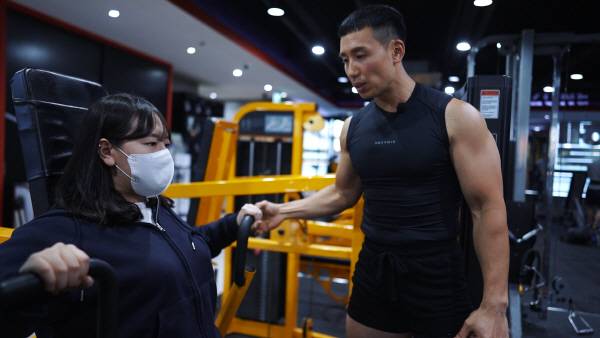 박성용 대표가 ‘체스트 프레스’ 운동기구 사용법을 지도하고 있다. 김태훈 피디