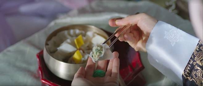 최근 종영한 퓨전사극 ‘슈룹’ 7화에 나온 냉동만두 간접광고의 한 장면. 극중 중전 화령(김혜수)이 아들들에게 받은 만두를 베어물고 있다. <사진제공=스튜디오드래곤>