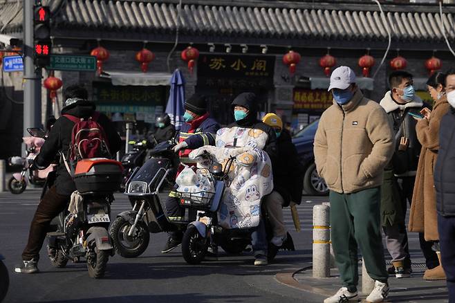 지난 7일 중국 수도 베이징에서 마스크를 쓴 주민들이 사거리 신호를 기다리고 있다. 베이징=AP뉴시스