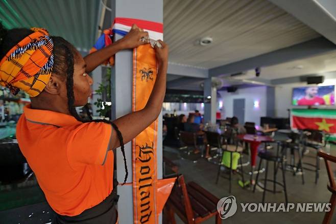 수리남의 한 식당에 네덜란드 응원 배너를 내거는 직원 [AFP=연합뉴스]