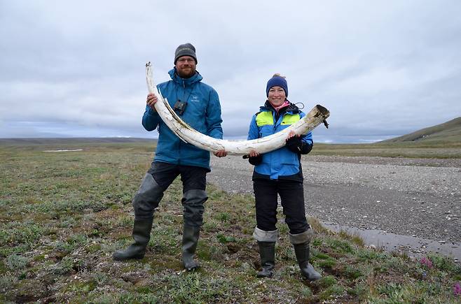 스웨덴 고유전학연구소의 러브 달렌 박사(왼쪽)가 시베리아에서 발굴한 매머드 상아 화석을 들고 있다. 연구진은 이 화석에서 165만~110만 년 전 DNA를 찾아내 해독했다./Gleb Danilov