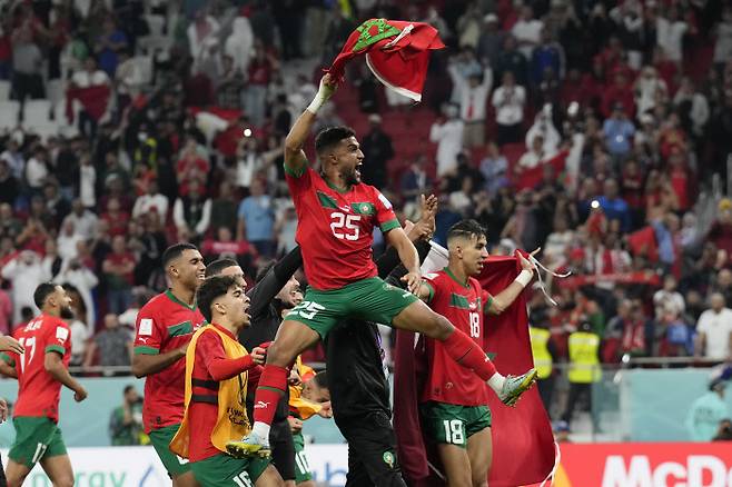 모로코 축구대표팀 선수들이 11일 카타르 도하 앗수마마 스타디움에서 포르투갈과 맞선 2022 카타르 월드컵 8강전에서 1-0으로 이겨 4강 진출을 확정한 뒤 국기를 들고 환호하고 있다. 도하 | AP연합뉴스