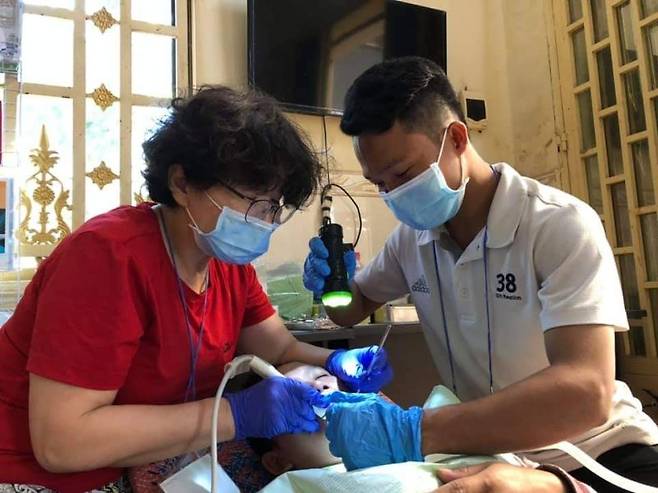 '캄보디아의 친구들' 정효경 대표(왼쪽)가 현지에서 치과 진료를 하고 있다. 부산사람이태석기념사업회 제공