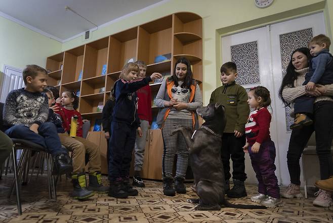 지난 7일 우크라이나 키이우 인근 도시 보야카의 한 심리치료센터에서 심리치료견 ‘바이스’와 놀이를 하고 있는 아이들. AP 연합뉴스