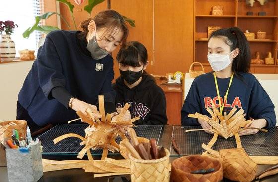 소중 학생기자단에게 바구니 모서리 만드는 법을 가르쳐주는 오나영(맨 왼쪽) 대표. 줄을 교차할 때마다 나무집게로 고정하고, 테이프가 느슨해진 곳은 잡아당겨 격자가 직각이 되게 한다.
