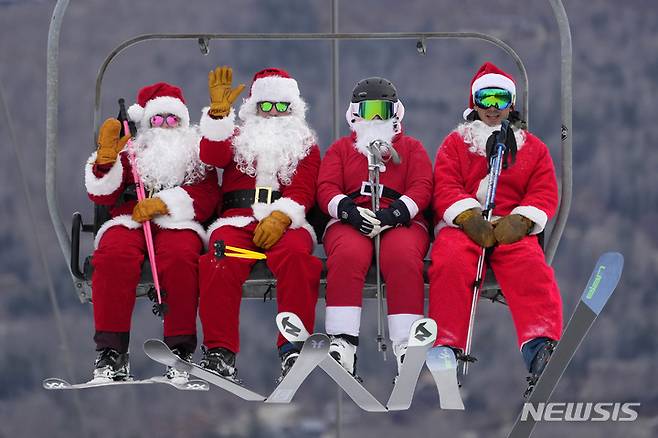 [뉴리=AP/뉴시스] 11일(현지시간) 미국 메인주 뉴리의 선데이 리버 스키 리조트에서 산타클로스 복장을 한 스키어들이 리프트를 타고 이동하고 있다. 2022.12.12.