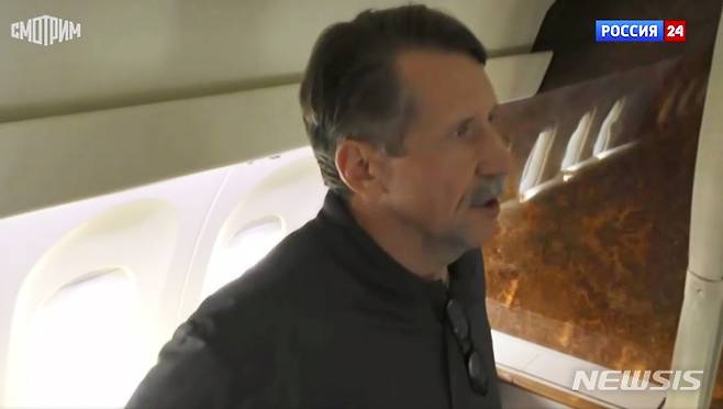 [AP/뉴시스] 9일(현지시간) 러시아 RU-24 TV가 제공한 영상을 캡처한 사진으로, '죽음의 상인'으로 불리는 무기 거래상 빅토르 부트가 미국에서 석방된 뒤 러시아 비행기 안에서 말하고 있다.