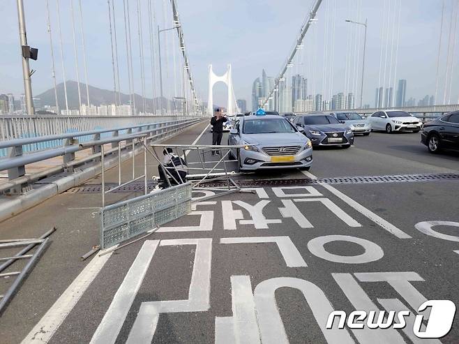 13일 오후 (부산=뉴스1) 백창훈 기자 = 부산 광안대교에서 불꽃놀이 행사를 위해 준비한 철구조물이 강풍에 쓰러져 운행하던 택시 앞 범퍼가 파손됐다. (부산경찰청 제공)