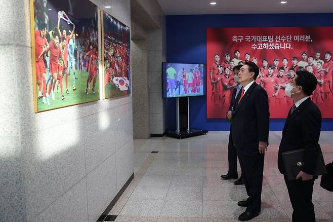 월드컵 16강 진출 환호하는 축구대표팀 사진 관람하는 윤석열 대통령 (서울=연합뉴스) 안정원 기자 = 윤석열 대통령이 지난12일 서울 용산 대통령실 청사 로비에서 카타르 월드컵 16강 진출 당시 환호하는 선수들을 촬영한 사진을 관람하고 있다. 대통령실은 경기 사진 이외에 국가대표팀 주장 손흥민 선수의 주장 완장과 사인볼, 축구화, 유니폼 등의 기념품도 전시했다. (연합뉴스)