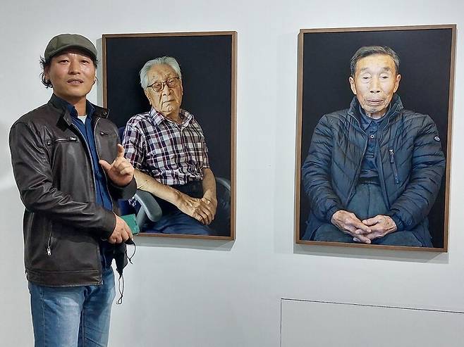 지난 8일 오후 서울 용산구 후암동 케이피갤러리의 전시장에서 만난 이규철 작가. 제주 4·3항쟁 수형자들을 찍은 초상사진 앞에서 작업 경위에 대해 이야기하고 있다. 노형석 기자