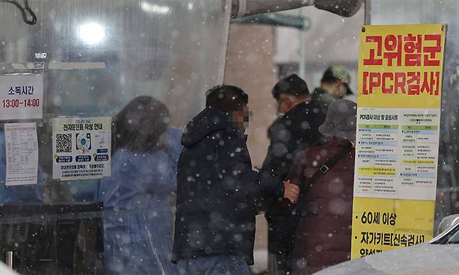 전국이 대체로 흐리고 눈이 내리는 13일 서울 마포구보건소 코로나19 선별진료소에서 검사를 받으려는 시민들이 이동하고 있다. 연합뉴스