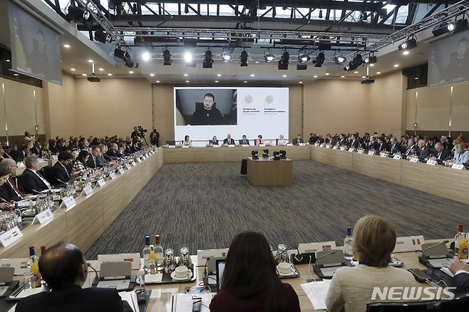 [파리=AP/뉴시스] 볼로디미르 젤렌스키(위) 우크라이나 대통령이 13일(현지시간) 프랑스 파리에서 열린 '우크라이나 국민과의 연대' 국제회의에 화상으로 참여하고 있다. 프랑스 정부는 우크라이나의 인프라 재건 지원을 위해 물자와 자금을 모으는 국제회의를 개최했다. 2022.12.13.