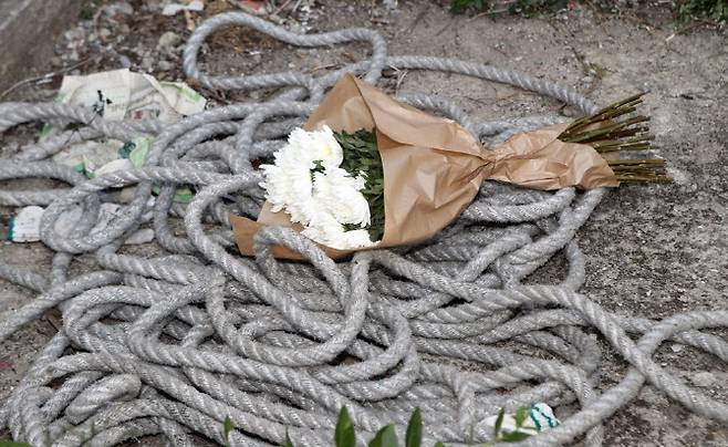 2017년 6월15일 작업자가 밧줄이 잘려 외벽에서 추락사한 사건이 발생한 경남 양산의 한 아파트 현장에 밧줄과 죽음을 애도하는 하얀 국화가 놓여 있다.(사진=연합뉴스)