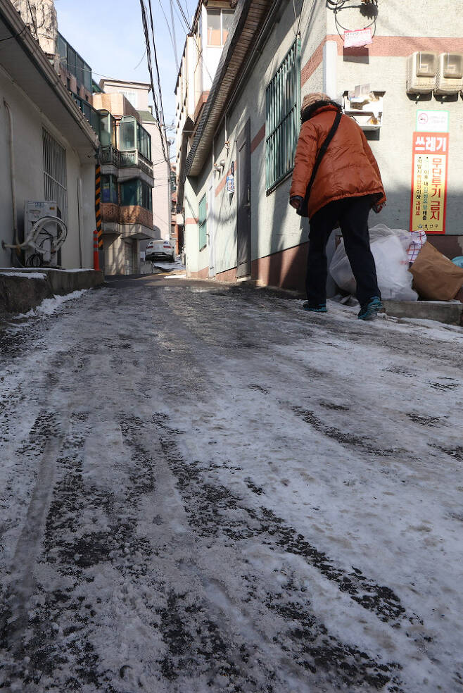 16일 오후 서울 용산구청 인근 주택가에서 한 시민이 눈이 얼어 빙판이 된 이면도로에서 이동하고 있다. (사진=연합뉴스)